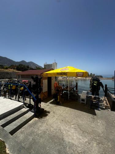 a yellow umbrella sitting on a dock next to the water at Manolya Hotel in Kérynia