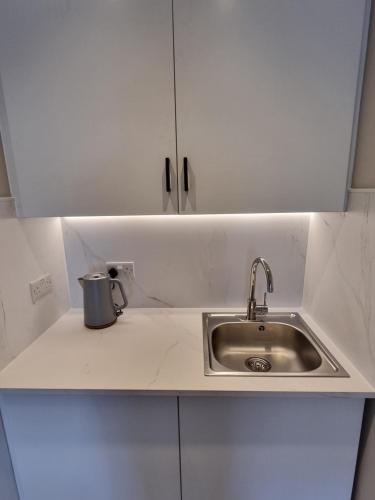 a white kitchen with a sink and a counter at The Ivy Apartments in Bournemouth