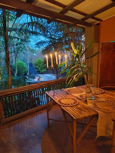 a wooden table on a balcony with candles on it at Dar Amane Guest House in Graskop