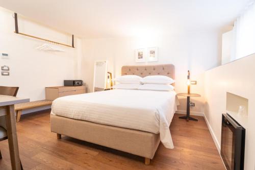 a bedroom with a large white bed and a desk at Four Points Flex by Sheraton Naples Marigliano in Marigliano