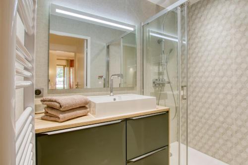 une salle de bain avec un lavabo et une douche en verre dans l'établissement Appartement piscine tennis accès privé plage Joïa, à Sanary-sur-Mer