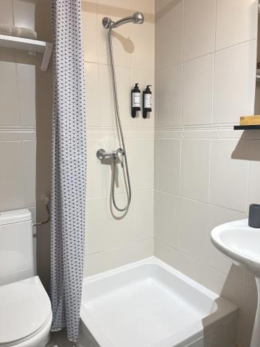 a bathroom with a shower and a toilet and a sink at O VIOLAS - Art Coffee & Guesthouse in Praia de Mira