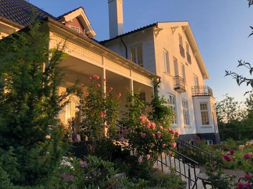 a white house with flowers in front of it at Eksklusiv taglejlighed med hav- og skovudsigt in Risskov