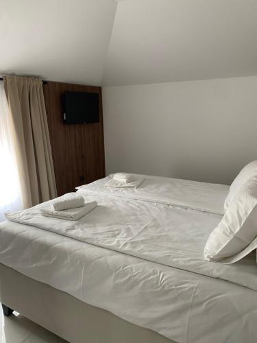 a white bed with white sheets and pillows on it at Apartmani Lazarevic Jagodina in Jagodina