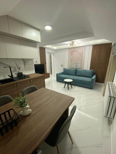 a living room with a table and a blue couch at Apartmani Lazarevic Jagodina in Jagodina