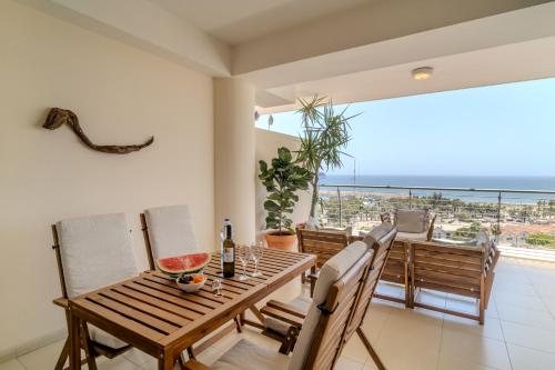 a dining room with a table and chairs and a balcony at Amazing Sea and Marina View City Center 2BDR Flat in Larnaka