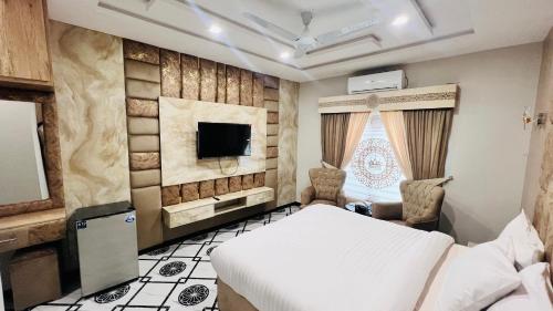 锡卡都Nestopia Hotel - Skardu的房间里有一张床和一台电视的卧室