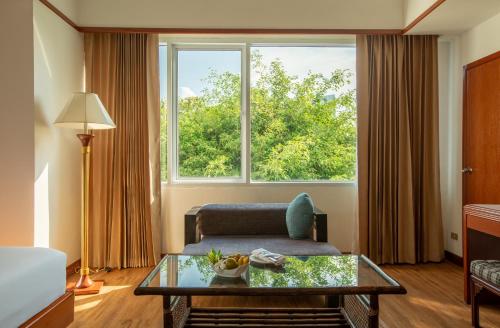 a living room with a couch and a large window at Centara Life Hotel Mae Sot in Mae Sot