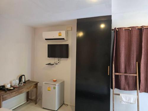 a small room with a refrigerator and a tv at แอทชฎา เชียงใหม่ @Shada Chiang Mai in Chom Thong