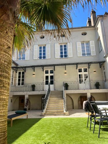 a building with a palm tree in front of it at L'Hotel Particulier in Louhans