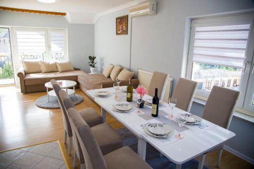 a dining room with a white table and chairs at Apartman Puente Viejo Mostar in Mostar
