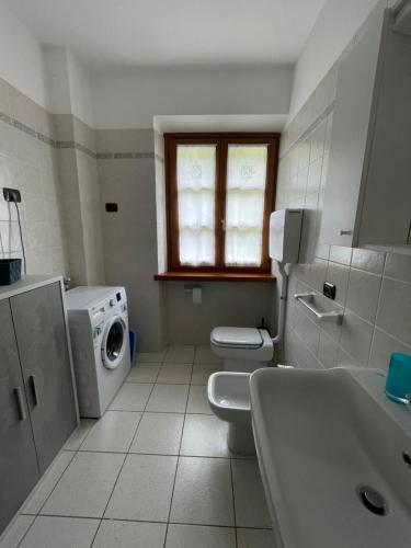 a bathroom with two toilets and a washing machine at Casa Valentina in Ledro