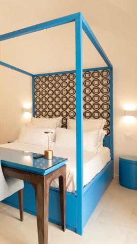 a bedroom with a blue canopy bed with a desk at PALAZZO SAN ROCCO in Sperlonga