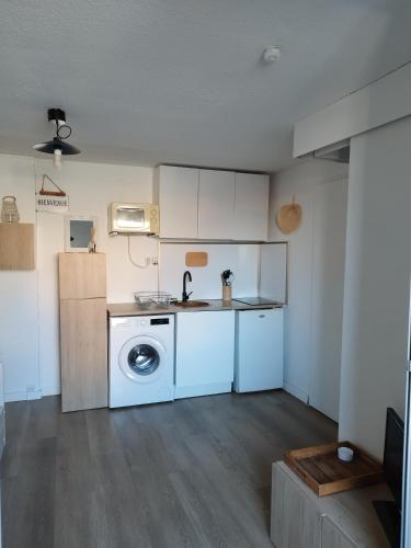 une cuisine avec une machine à laver dans une pièce dans l'établissement Studio cabine, à Saint-Cyprien