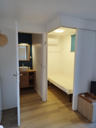 une petite chambre avec un lit et un miroir dans l'établissement Studio cabine, à Saint-Cyprien