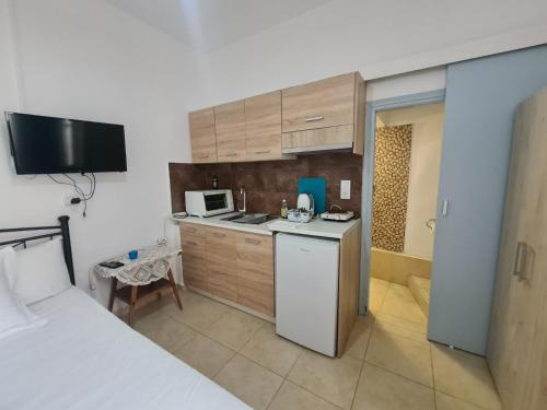 małą kuchnię z lodówką i kuchenką mikrofalową w obiekcie Aithra -cosy studio in centre of Poros w Poros