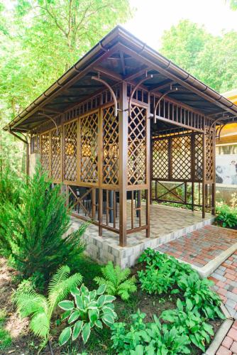 a small wooden building with a roof in a garden at Sovinyon Resort in Odesa