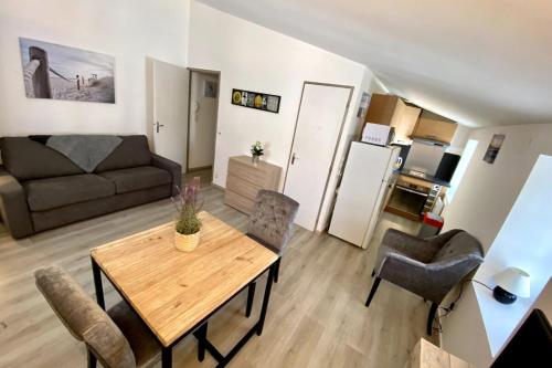 un salon avec une table et un canapé dans l'établissement Cosy studio in the center of the village, à Saint-Martin-de-Ré