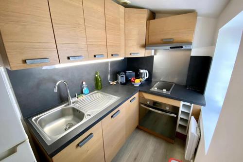 Elle comprend une petite cuisine avec des placards en bois et un évier. dans l'établissement Cosy studio in the center of the village, à Saint-Martin-de-Ré
