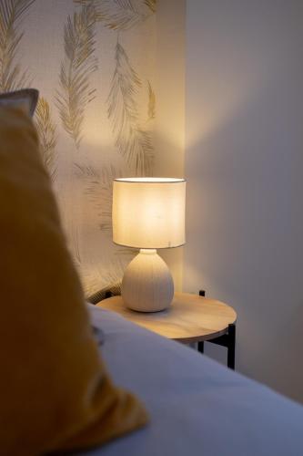 a lamp sitting on a table next to a bed at Homely apartment by urbanhosting in Santander