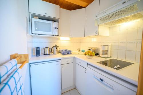 une cuisine blanche avec un évier et un micro-ondes dans l'établissement T1 with mezzanine bedroom between port and beach, à Saint-Martin-de-Ré