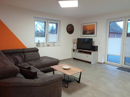 Una sala de estar con un sofá y un televisor. en Ferienhaus Ebsen HH 1, en Steinberg