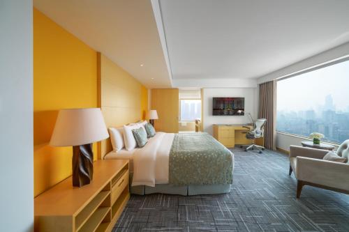 a large hotel room with a bed and a desk at Marco Polo Wuhan in Wuhan
