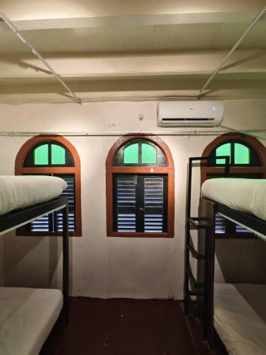 a room with two windows and three bunk beds at Red Inn Court in George Town