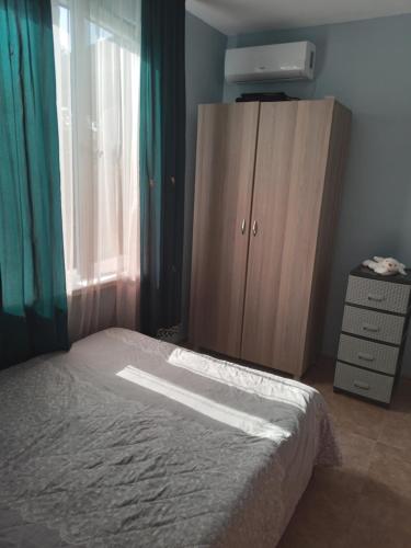 a bedroom with a bed and a dresser and a window at E L A in K'obulet'i