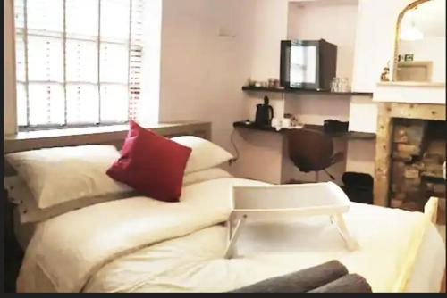 a bedroom with a white bed with a red pillow at Turner - Turnbridge Guest House in Burnley