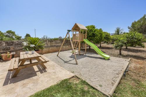 a playground with a slide and a swing set at Es Cos in Algaida