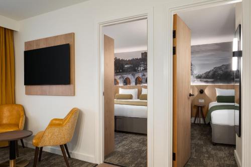 a hotel room with two beds and a television at Super 8 by Wyndham Durham in Durham
