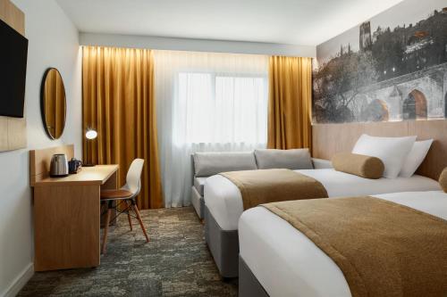 a hotel room with two beds and a desk at Super 8 by Wyndham Durham in Durham