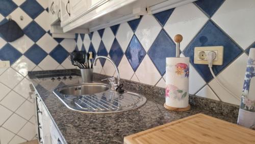 Una encimera de cocina con un fregadero y una toalla. en Bungalow in the heart of Arguineguín 2, en Arguineguín