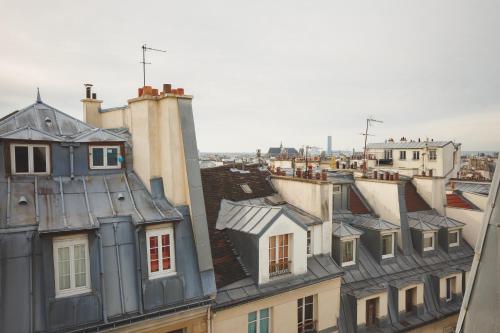 a view of roofs of buildings in a city at Hôtel Bonne Nouvelle in Paris