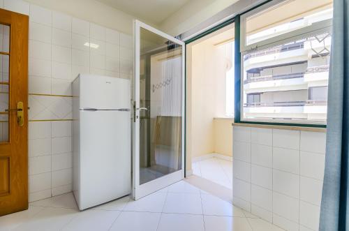 frigorifero bianco in cucina con finestra di TURIM Algarve Mor Apartamentos Turísticos a Portimão