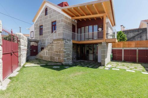 a house with a balcony on top of a yard at Casa da Bisa Rita in Aldeia Formosa