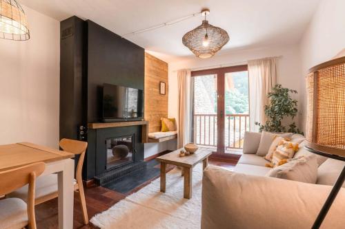a living room with a couch and a fireplace at Apartament la Xisqueta - Vall Fosca - L'Amfitriona in Espúy