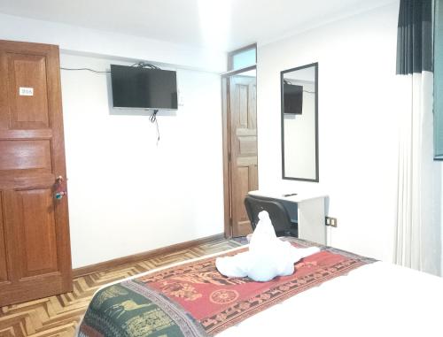 una habitación con una cama con un animal de peluche. en Hostel Tupac Yupanqui House, en Cusco