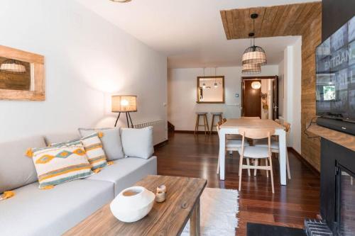a living room with a couch and a table at Apartament la Xisqueta - Vall Fosca - L'Amfitriona in Espúy