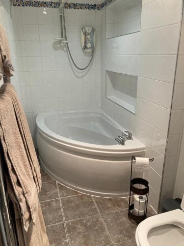 Un baño blanco con bañera y inodoro. en The Bijou on Park View, en Harrogate