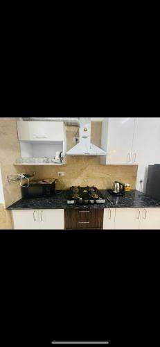 a kitchen with white cabinets and a stove top oven at Wanderers inn- beautiful hills view in Dehradun