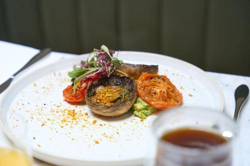 a plate of food with tomatoes and meat on a table at The Store in Oxford