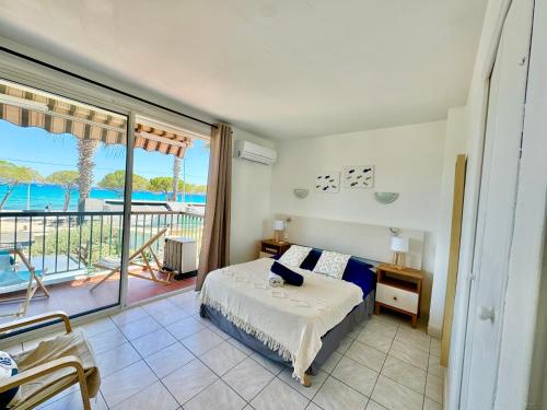 Un dormitorio con una cama y vista al mar. en T2 BORD DE MER vue plages WIFI climatisé parking inclus, en La Ciotat