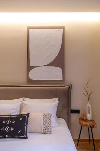 a bedroom with a bed with a picture above it at Plaza Filellinon in Nafplio