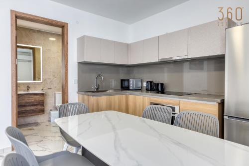a kitchen with a white table and chairs at The St Pauls Bay Escape Suites by 360 Estates in St Paul's Bay