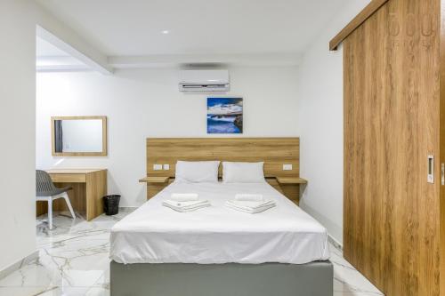 a bedroom with a large bed with a wooden headboard at The St Pauls Bay Escape Suites by 360 Estates in St Paul's Bay
