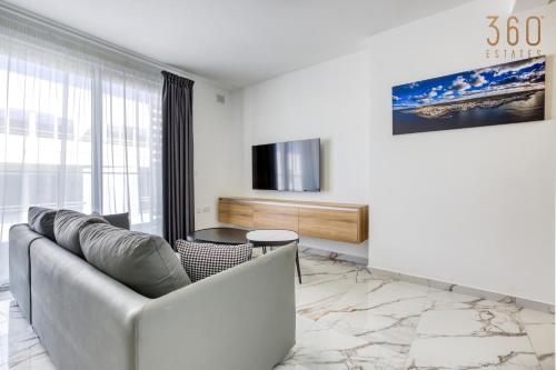 a living room with a couch and a tv at The St Pauls Bay Escape Suites by 360 Estates in St Paul's Bay