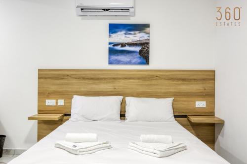 a bedroom with a bed with two towels on it at The St Pauls Bay Escape Suites by 360 Estates in St Paul's Bay