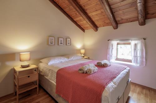 two beds in a bedroom with two towels on them at Villa Oros in StrinÃ½las